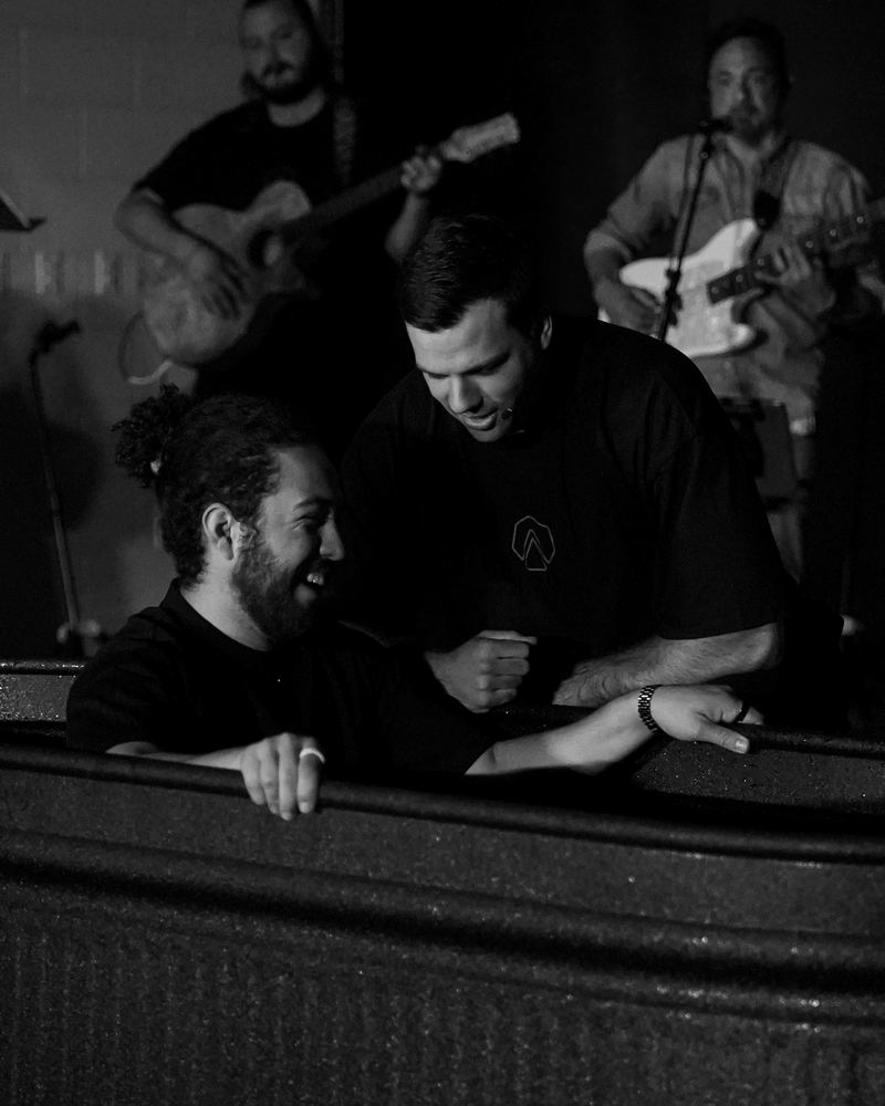 A man in the baptism tank laughing as the pastor talks with him