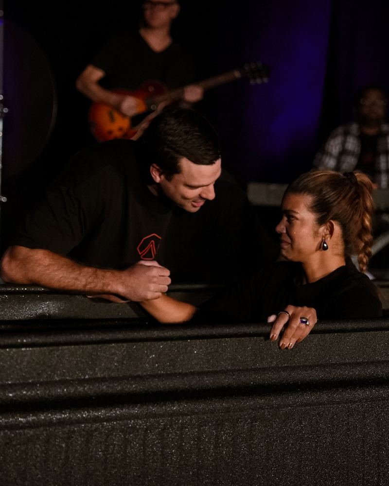A woman in the tank with tears on her face, smiling at the pastor