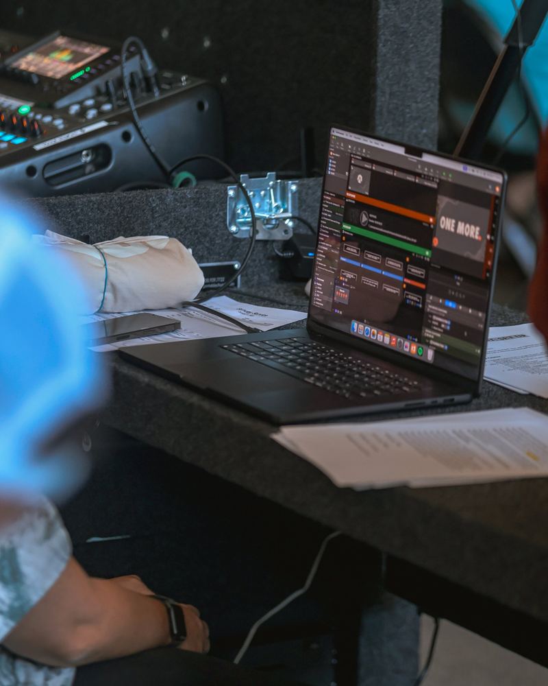 A laptop running the slides next to the sound board