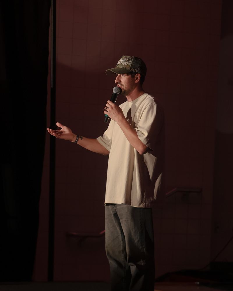 A man on stage talking into a microphone