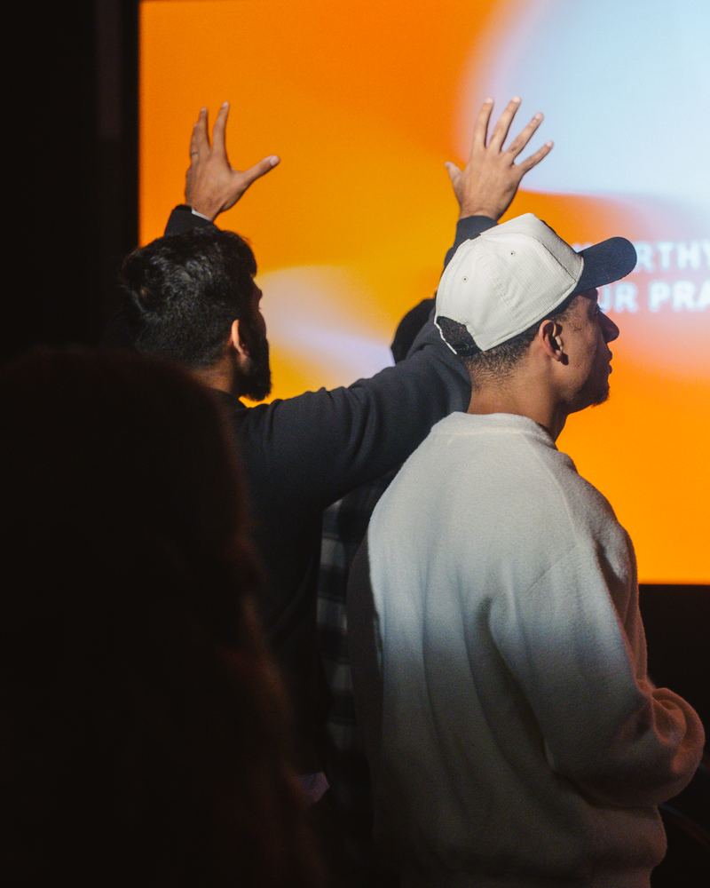A man with both hands raised during worship