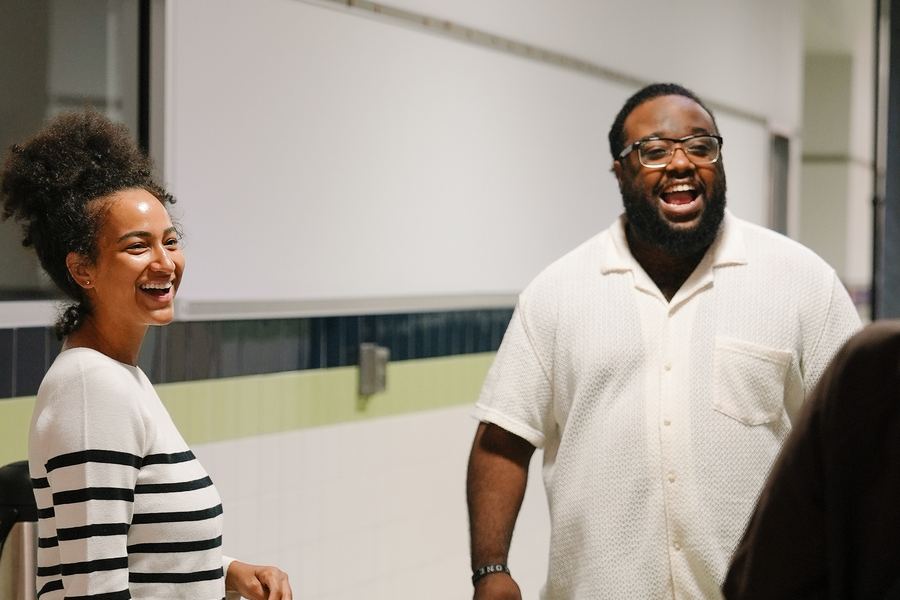 A man and a woman laughing together in the hallway