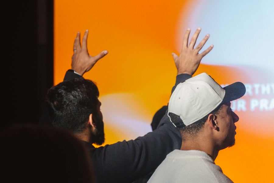 A man with both hands raised during worship